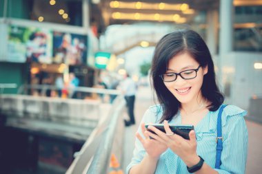 Şehirde Smartphone kullanan genç kadın