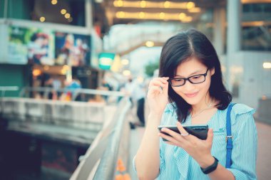 Şehirde Smartphone kullanan genç kadın