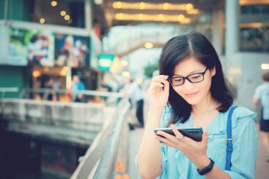 Şehirde Smartphone kullanan genç kadın