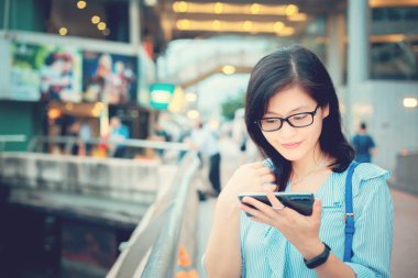 Şehirde Smartphone kullanan genç kadın