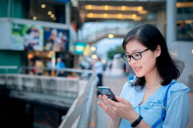 Şehirde Smartphone kullanan genç kadın