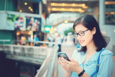 Şehirde Smartphone kullanan genç kadın