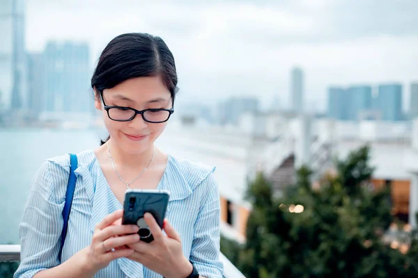 在城市中使用智能手机的年轻女人 — 图库照片