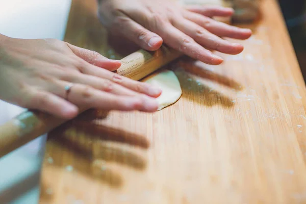 女性は団子の皮を準備し 木製のテーブルの上に生地を作る — ストック写真