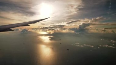 Gün batımında deniz üzerinde uçan uçak kanadı