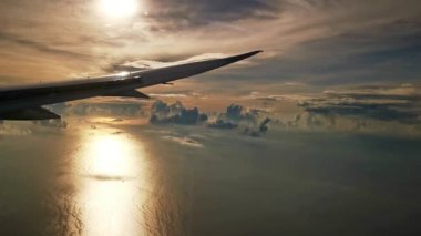 Gün batımında deniz üzerinde uçan uçak kanadı