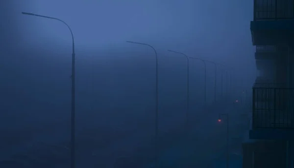 Fog in the night city. Landscape with a street enveloped in thick fog.