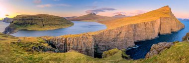 Leitisvatn Gölü ve Tralanipan, günbatımında köle kayası. Vagar Adası, Faroe Adaları. Danimarka