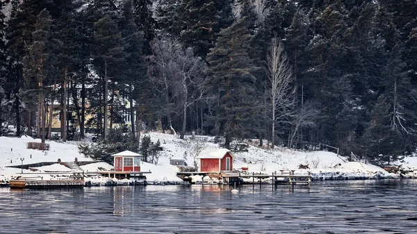 Sweden house in the wintertime. Nature on the shore of the fjord