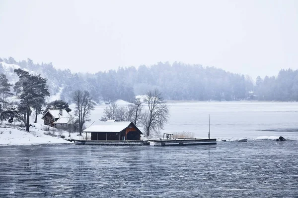 Sweden house in the wintertime. Nature on the shore of the fjord