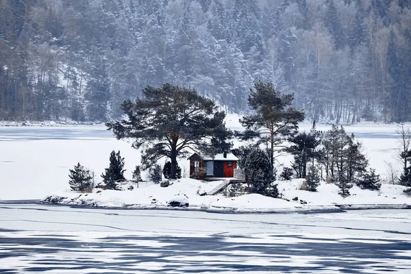 Sweden house in the wintertime. Nature on the shore of the fjord
