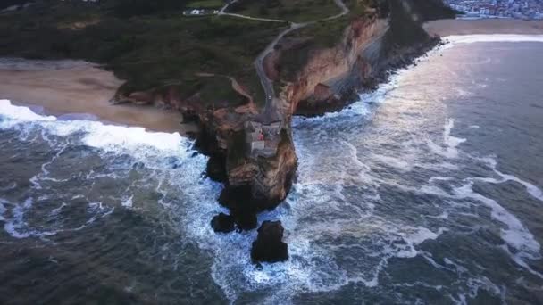 An iconic place on the Atlantic coast, the Mecca of big-wave surfing. View of Nazare's lighthouse in Zon North Canyon, place with the biggest waves in Europe, Nazare, Portugal. — Stock Footage Iconic Place Atlantic Coast Mecca Big Wave Surfing View Nazare Stock Footage