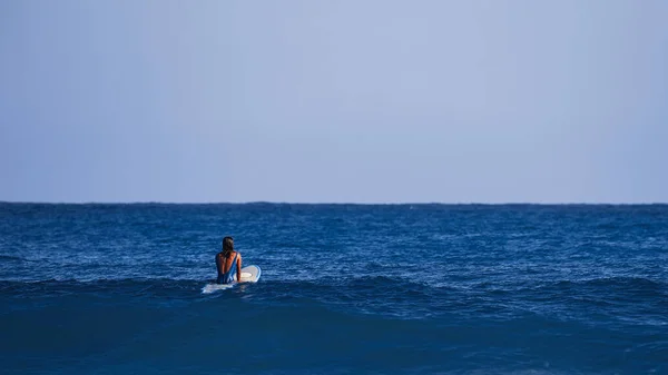 Ragazza surfista in attesa di un'onda. Scuola di surf. Bella giovane donna in costume da bagno va in mare in calda giornata estiva. Surfista sull'onda. bellissima onda oceanica. Attività di sport acquatici — Foto Stock