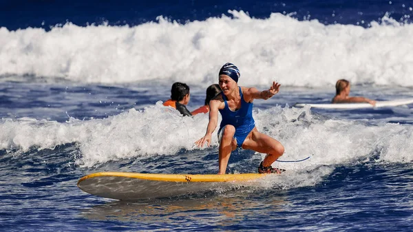 美しい若い女性がサーフボードの上に立つことを学んでいます。サーフスクール。水スポーツ,大西洋ドミニカ共和国.2016年12月29日 — ストック写真