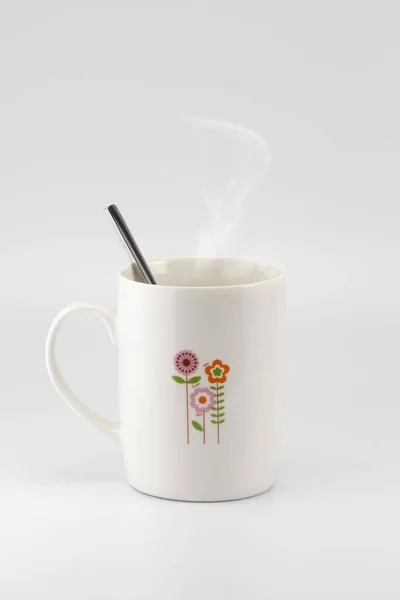 Una taza con gráfico de flores en la superficie con vapor — Foto de Stock