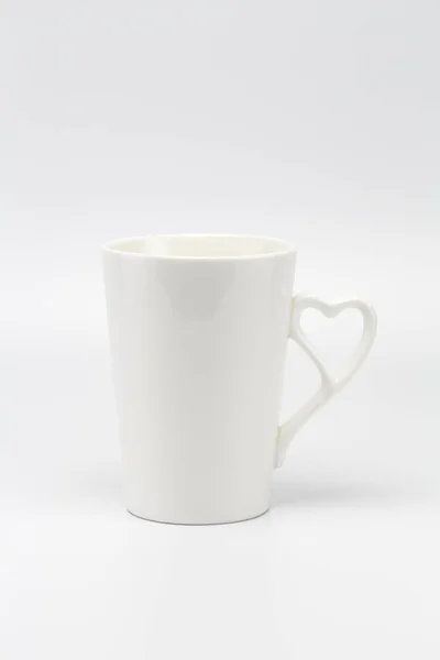 A white creamy cup with heart symbol handle — Stock Photo, Image