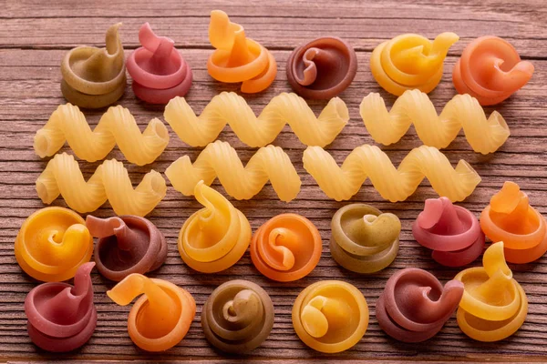 Colored pasta on wooden table — Stock Photo, Image