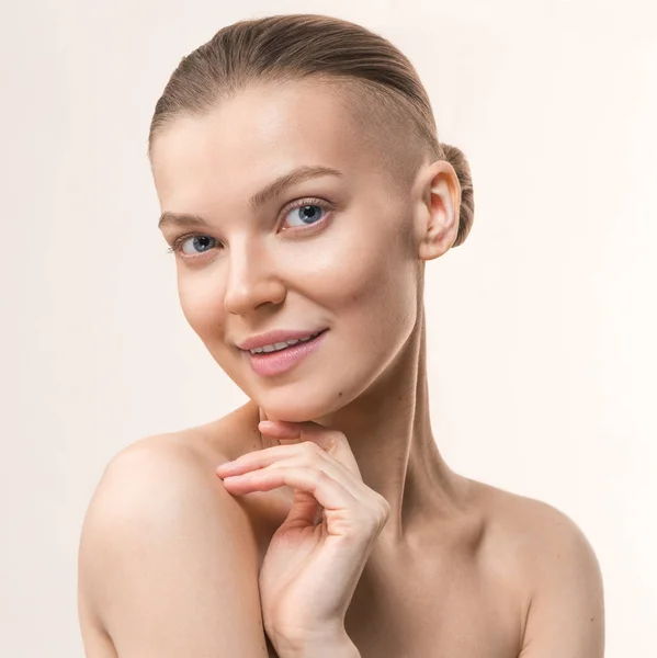 Joven mujer de belleza con templo afeitado. Retrato de estudio. Cuidado de la salud, concepto de cuidado de la piel en el fondo de color melocotón —  Fotos de Stock