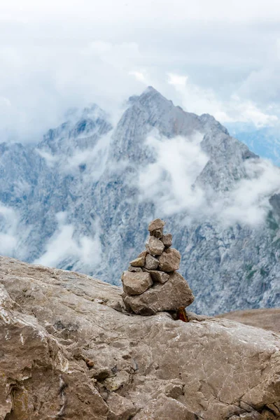 Stones cairn bridging on Zugspitze peak, Alps, Alemanha. Alpes bávaros no fundo. Touristic, conceito de caminhadas Imagem De Stock