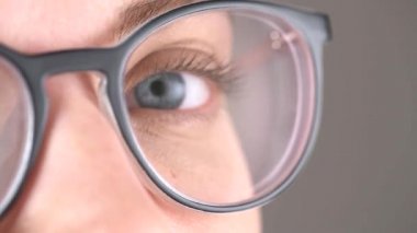 Blue eyes of the girl in glasses close-up, glasses for vision correction, beautiful stylish frame