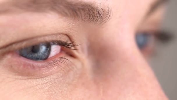 Gray-blue pupil of a young girl moves left, right, watching some movement or reading — 图库视频影像