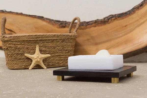Yazın deniz temalı dekorasyon. Sabun, sabun ve çiğ ahşap parçasıyla dekore edilmiş beton arka planda bir denizyıldızı. Banyo, spa ve sağlık teması. Çevre dostu, doğal ışık