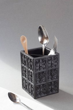 Çatal, bıçak ve tahta kaşıkla, yukarıdan görünen siyah çatal bıçak takımı. Minimalizm, minimalist tarz. Doğal, organik. Işık ve gölge, doğal ışık. İllüzyon, konsept, kavramsal