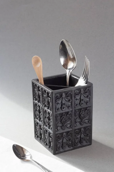 Çatal, bıçak ve tahta kaşıkla, yukarıdan görünen siyah çatal bıçak takımı. Minimalizm, minimalist tarz. Doğal, organik. Işık ve gölge, doğal ışık. İllüzyon, konsept, kavramsal