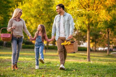 Mutlu aile parkta piknik yapıyor. Üç çocuklu mutlu aile birlikte eğleniyor. Aile eğlencesi dışarıda..