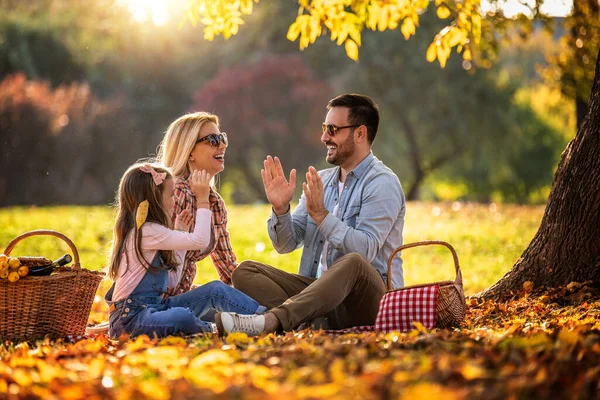 Mutlu aile parkta piknik yapıyor. Üç çocuklu mutlu aile birlikte eğleniyor. Aile eğlencesi dışarıda..