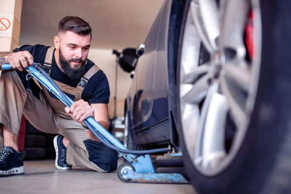 Bonito Jovem Trocando Pneus Garagem — Fotografia de Stock