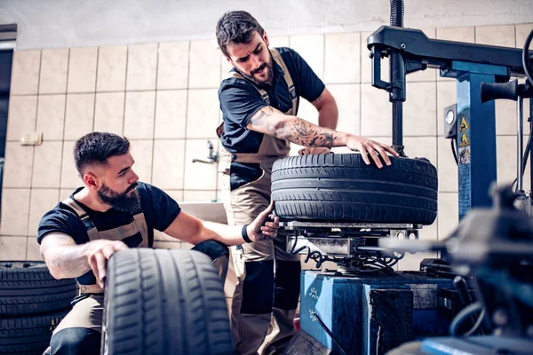 Tamirci tamirhanede lastik tutuyor..