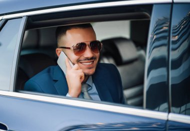 Genç başarılı iş adamı yeni arabasıyla araba kullanıyor. İş ve seyahat konsepti..