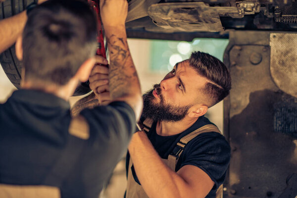 Mechanic in car service.Auto mechanics working in garage. 