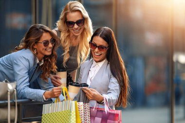 Alışveriş çantasıyla gülümseyen iş kadınlarının portresi. İnsanlar, moda ve alışveriş konsepti..