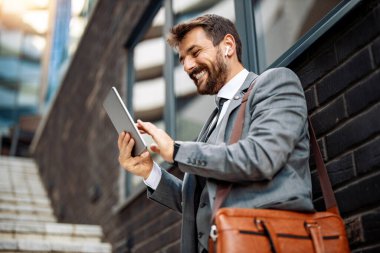 Genç işadamı şehir sokaklarında tabletle video görüşmesi yapıyor. İnsanlar, iş dünyası, internet iletişimi ve iş kavramı.