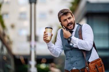 Zeki bir telefon kullanan çekici genç bir işadamı. Şehirde yakışıklı bir işadamının portresi..