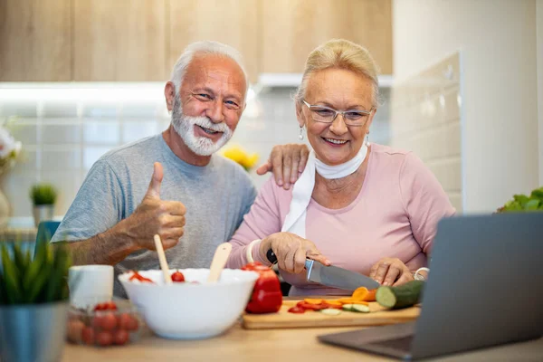 Senior couple cooking healthy food.Senior couple is talking and smiling while cooking healthy food in ther kitchen.