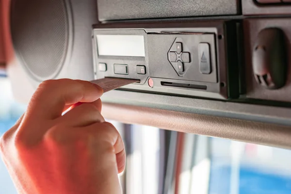 Kamyon sürücüsü tachograph aygıtı üzerinde sürücü kartı ve menü işlemleri yapıyor.