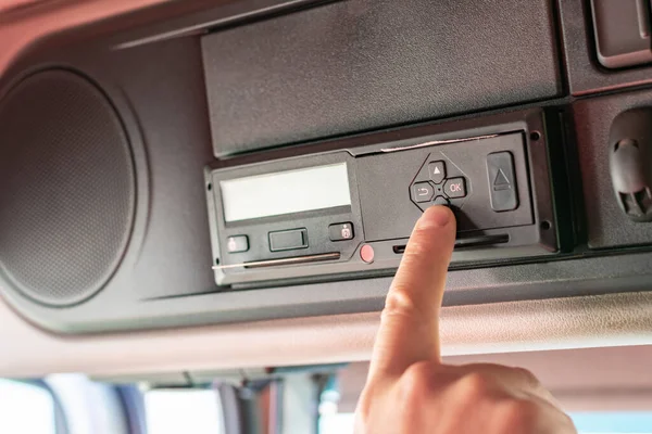 Kamyon sürücüsü tachograph aygıtı üzerinde sürücü kartı ve menü işlemleri yapıyor.