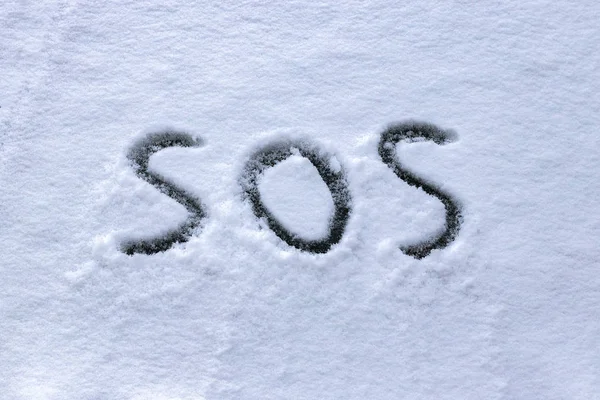 "SOS"geschreven in de sneeuw Rechtenvrije Stockafbeeldingen