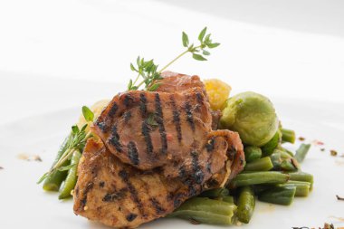 Barbekü et beyaz tabakta sebze ile.