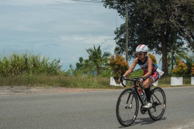 Langkawi, Malezya-Kasım 11: sporcu üzerinde 11 Kasım 2017 siyah kum Beach, Langkawi Adası, Malezya yakınındaki Ironman Langkawi triatlon sırasında bir bisiklet sürmek.