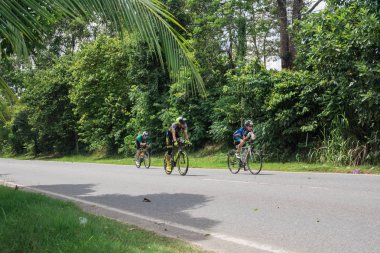 Langkawi, Malezya-Kasım 11: sporcu üzerinde 11 Kasım 2017 siyah kum Beach, Langkawi Adası, Malezya yakınındaki Ironman Langkawi triatlon sırasında bir bisiklet sürmek.