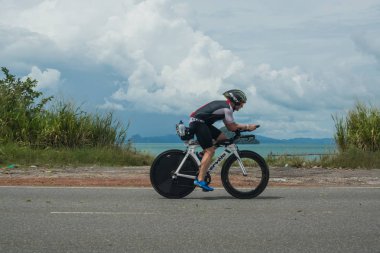 Langkawi, Malezya-Kasım 11: sporcu üzerinde 11 Kasım 2017 siyah kum Beach, Langkawi Adası, Malezya yakınındaki Ironman Langkawi triatlon sırasında bir bisiklet sürmek.