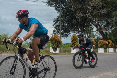 Langkawi, Malezya-Kasım 11: sporcu üzerinde 11 Kasım 2017 siyah kum Beach, Langkawi Adası, Malezya yakınındaki Ironman Langkawi triatlon sırasında bir bisiklet sürmek.