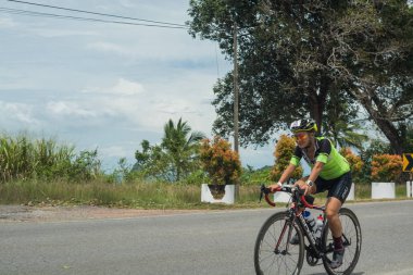 Langkawi, Malezya-Kasım 11: sporcu üzerinde 11 Kasım 2017 siyah kum Beach, Langkawi Adası, Malezya yakınındaki Ironman Langkawi triatlon sırasında bir bisiklet sürmek.