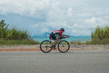 Langkawi, Malezya-Kasım 11: sporcu üzerinde 11 Kasım 2017 siyah kum Beach, Langkawi Adası, Malezya yakınındaki Ironman Langkawi triatlon sırasında bir bisiklet sürmek.