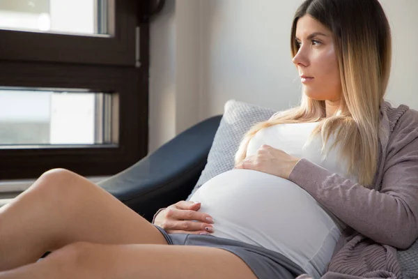 Mooi Zwanger Meisje Zit Thuis Bank Kijkt Door Het Raam — Stockfoto