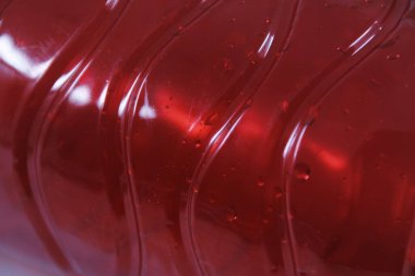 Beyaz arka planda kırmızı plastik şişe